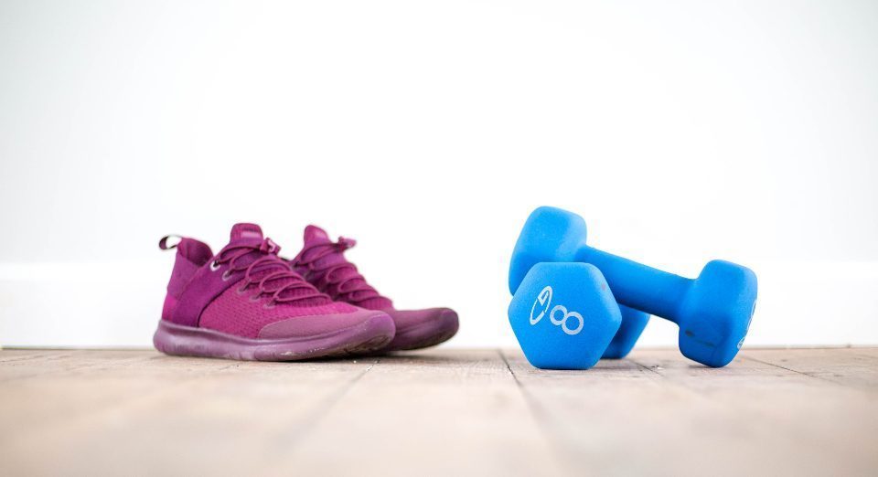 Baskets et haltères posés au sol du studio de sport